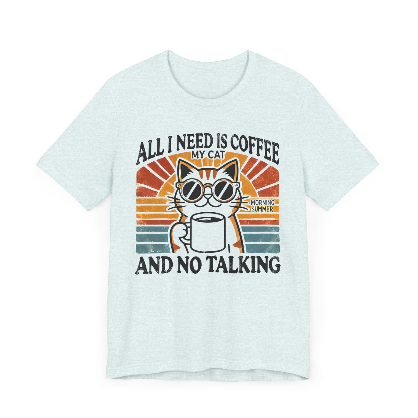 A light-colored t-shirt with a retro design of a cat wearing sunglasses, holding a coffee cup, and the text "All I Need is Coffee and My Cat.