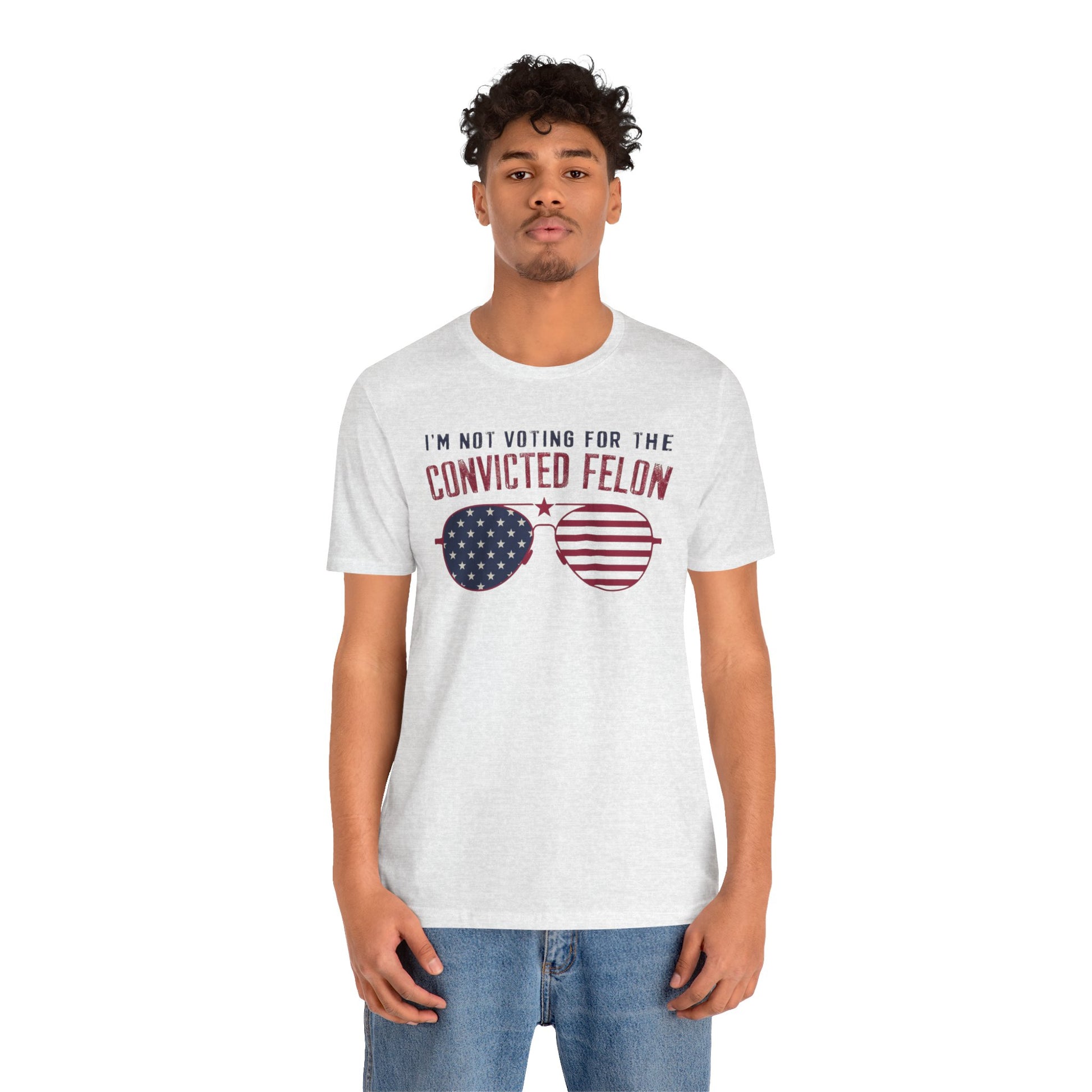 White t-shirts featuring the text "I'm Not Voting for the Convicted Felon" with a patriotic design of American flag sunglasses.