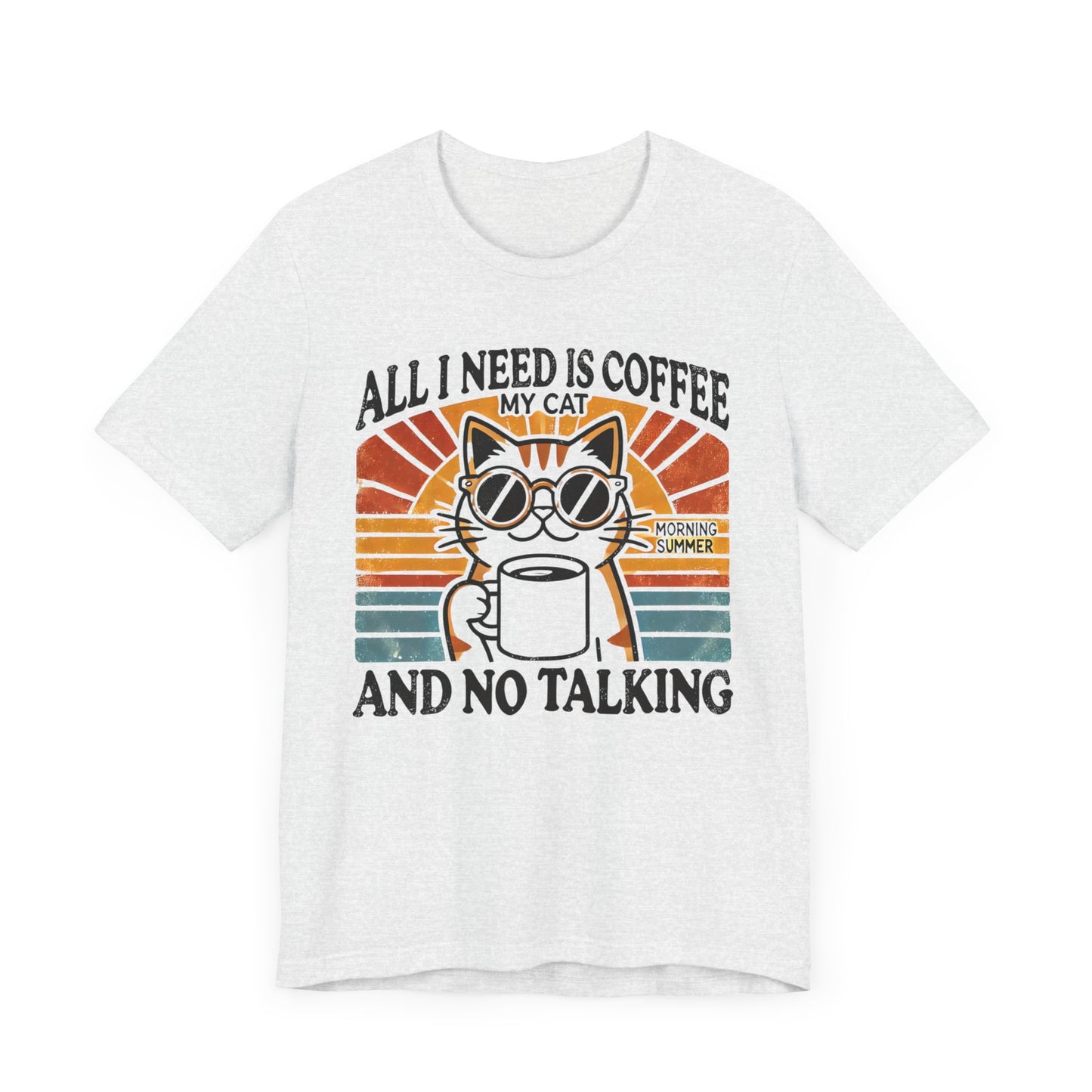 A light-colored t-shirt with a retro design of a cat wearing sunglasses, holding a coffee cup, and the text "All I Need is Coffee and My Cat.