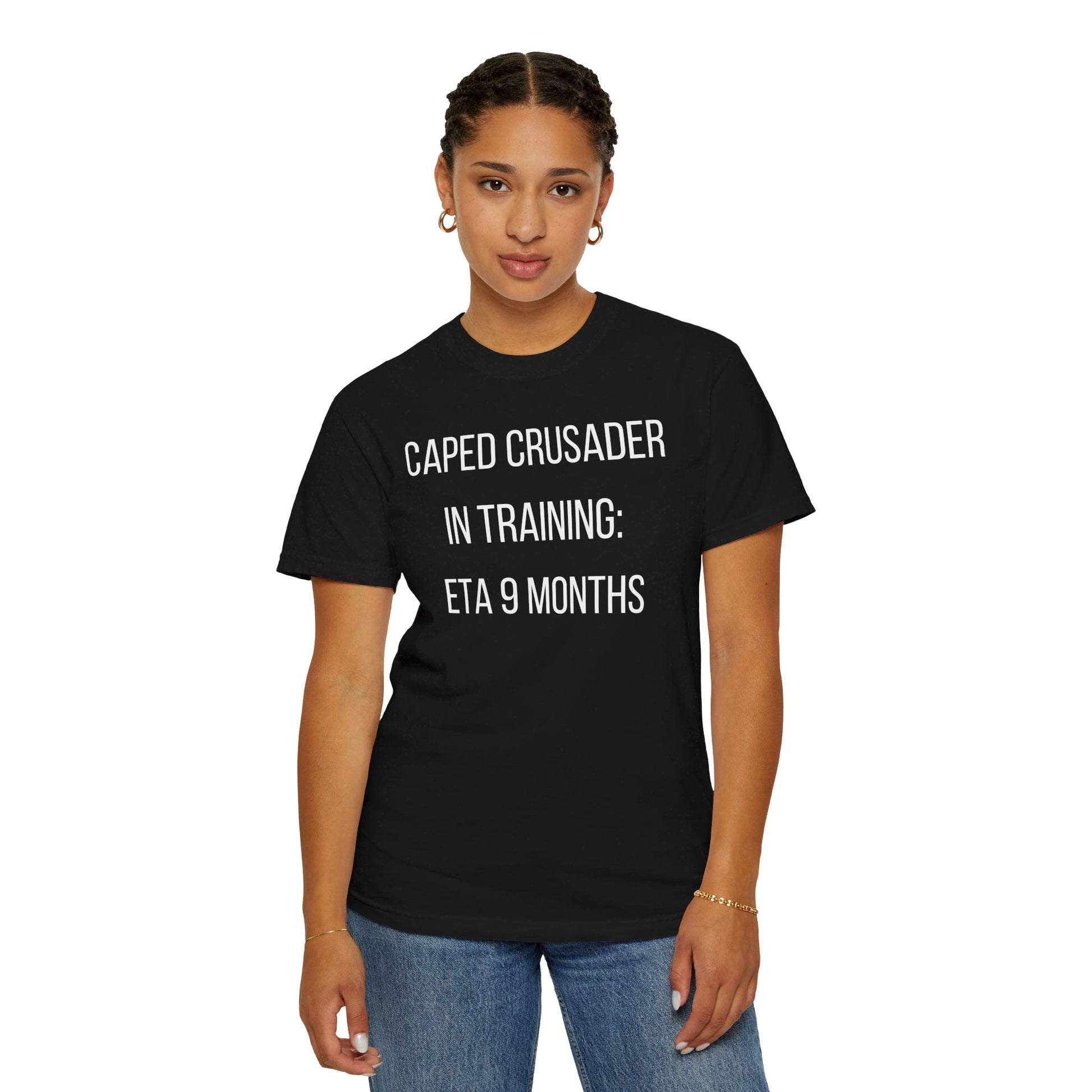 Black t-shirt with the text "Caped Crusader in Training: ETA 9 Months" in a playful superhero-themed font.