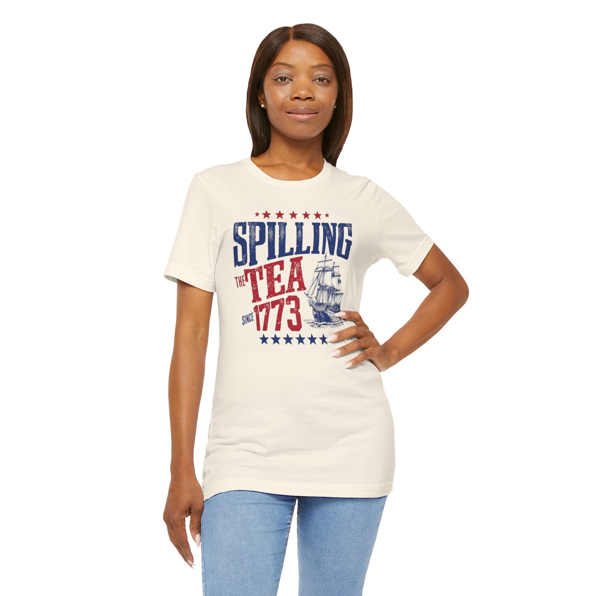 Various t-shirts featuring the text "Spilling the Tea Since 1773" with vintage-inspired graphics of ships and patriotic elements.