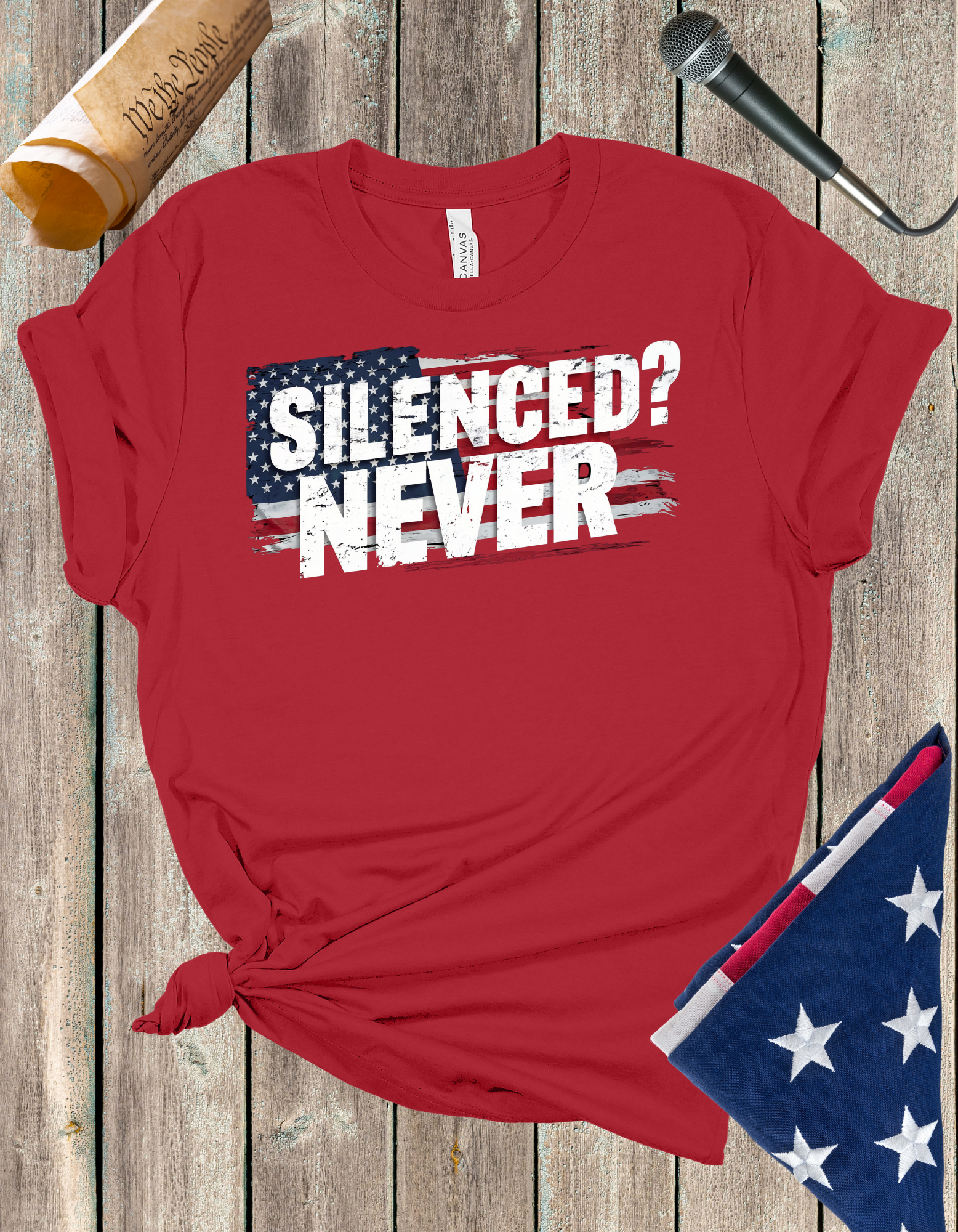 Silenced? Never. t-shirt with a distressed American flag background, featuring bold white text