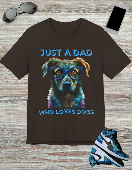 T-shirt featuring a vibrant and colorful graphic of a dog wearing glasses, with the text "Just a Dad Who Loves Dogs" prominently displayed. Perfect for dog dads and Father's Day gifts.