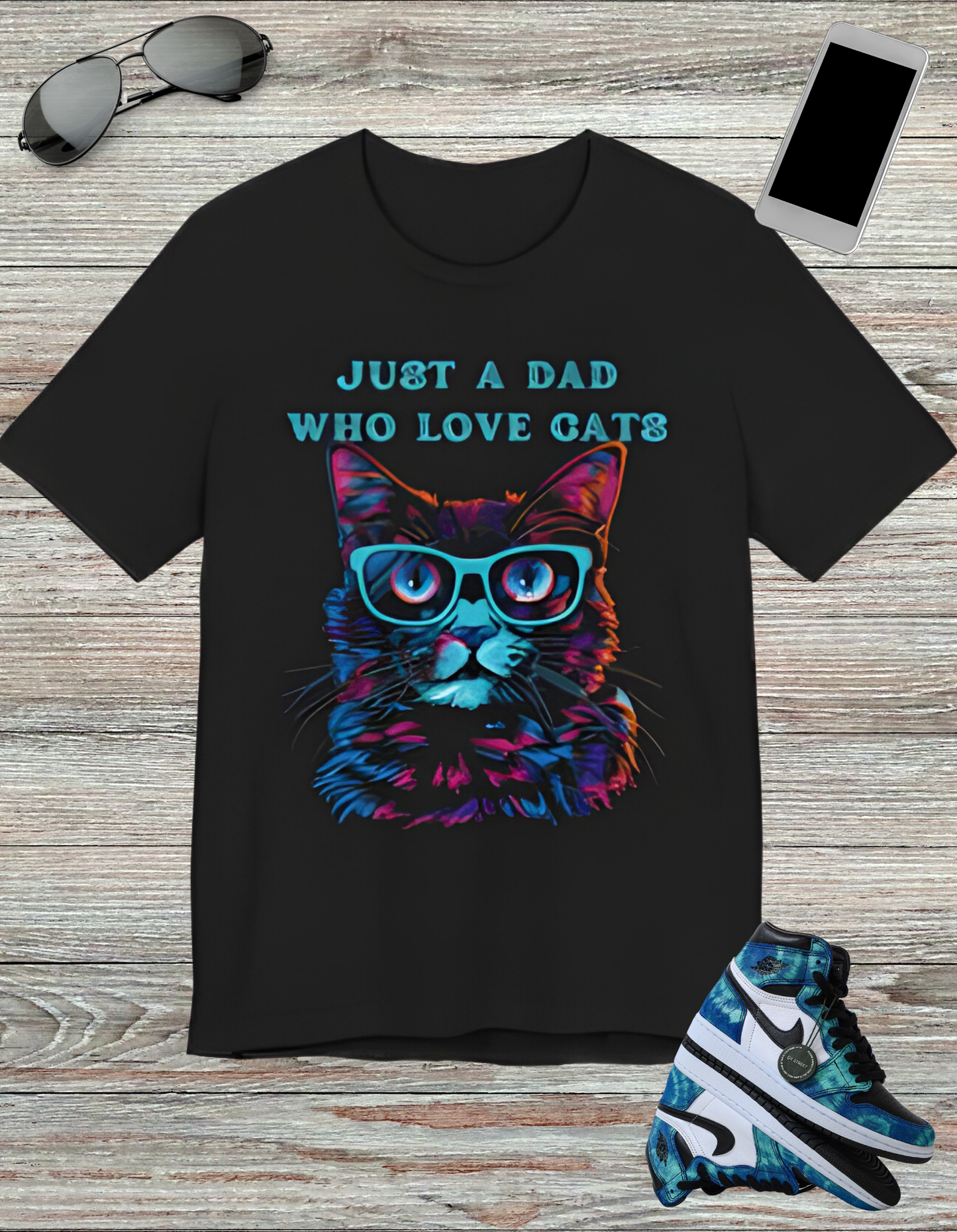 T-shirt featuring a vibrant and colorful graphic of a cat wearing glasses, with the text "Just a Dad Who Loves Cats" prominently displayed. Perfect for cat dads and Father's Day gifts.