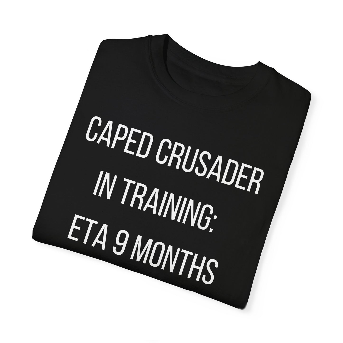 Black t-shirt with the text "Caped Crusader in Training: ETA 9 Months" in a playful superhero-themed font.