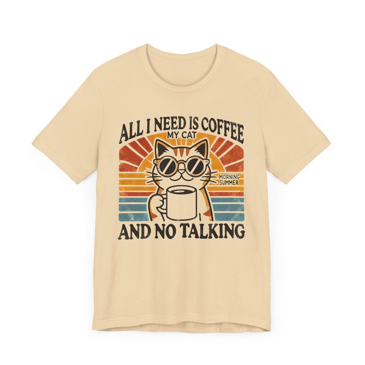 A light-colored t-shirt with a retro design of a cat wearing sunglasses, holding a coffee cup, and the text "All I Need is Coffee and My Cat.