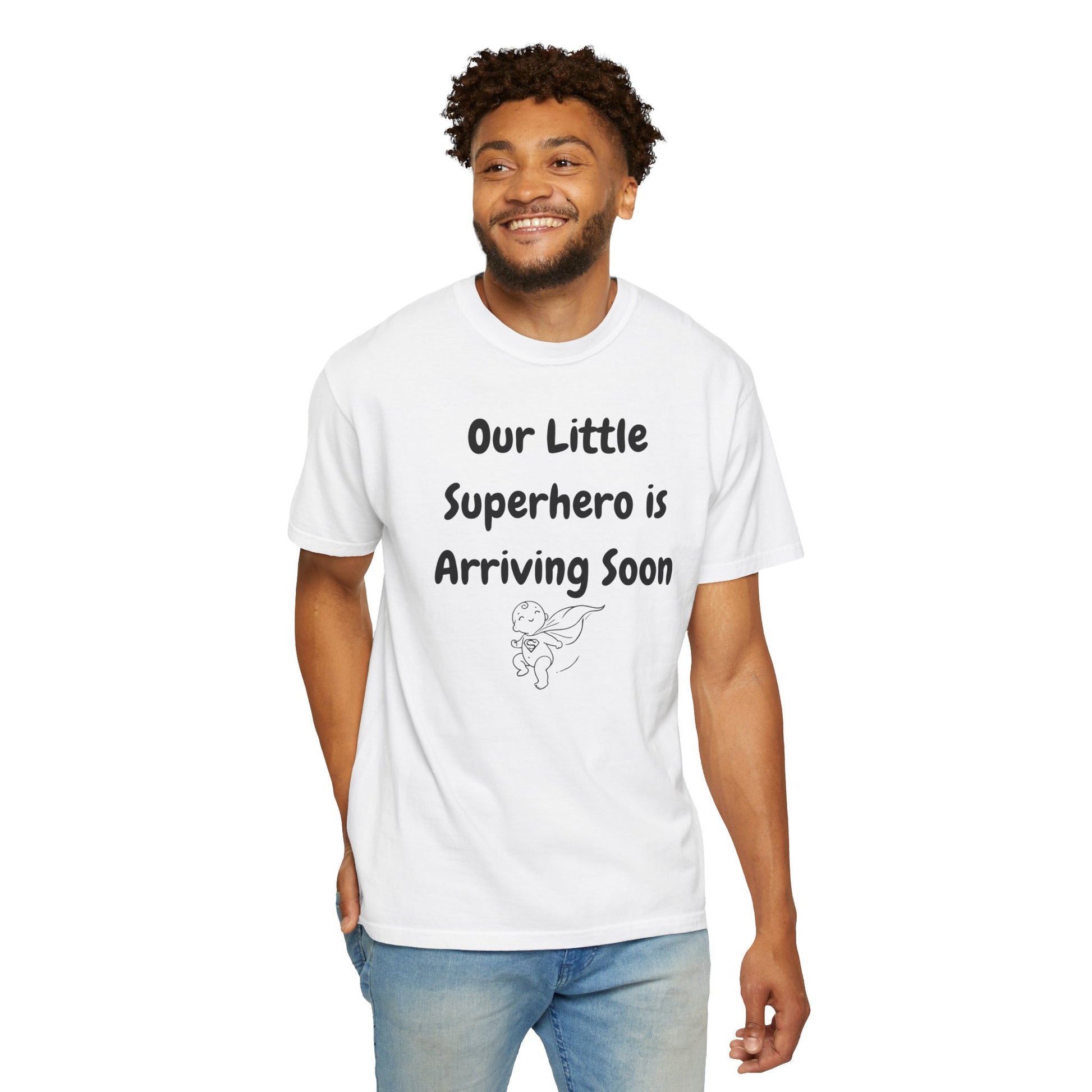 White t-shirt featuring the text "Our Little Superhero is Arriving Soon" with a cute superhero graphic.