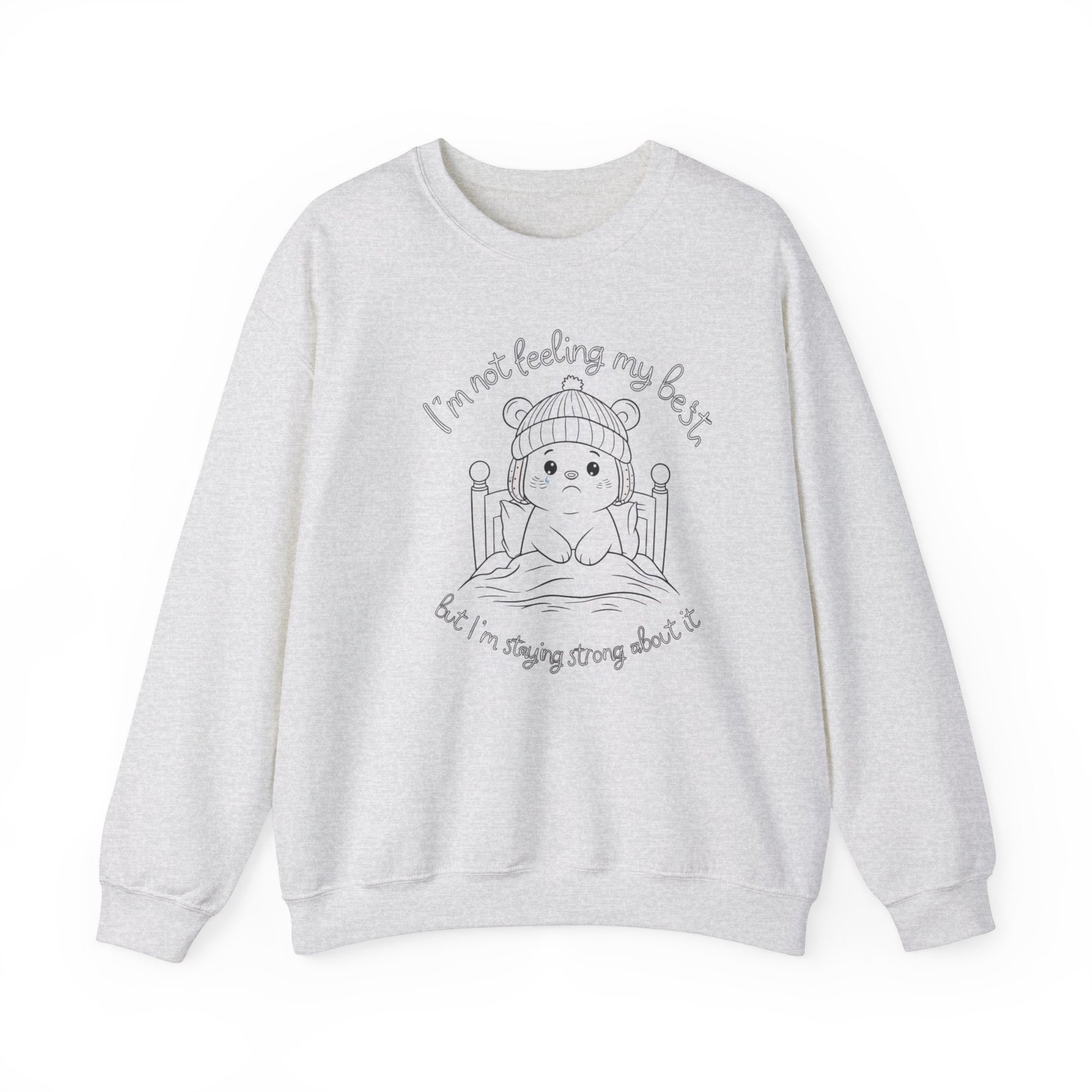 Adorable ash white sweatshirt with a line-art illustration of a bear in bed, with text 'I'm not feeling my best' and 'but I'm staying strong about it.'